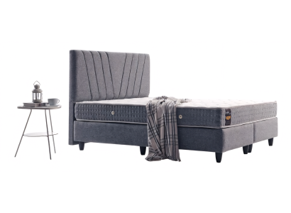 Praktisches Bett in stilvollem Grau mit einem dekorativ abgesteppten Kopfteil