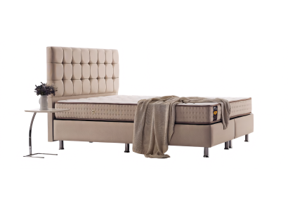 Filigranes Bett mit Steppung am Kopfteil und Chromfüßen ausgeführt in Beige