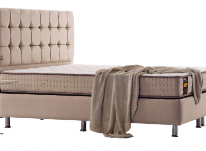 Filigranes Bett mit Steppung am Kopfteil und Chromfüßen ausgeführt in Beige